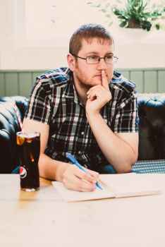 man wearing black plaid shirt sitting